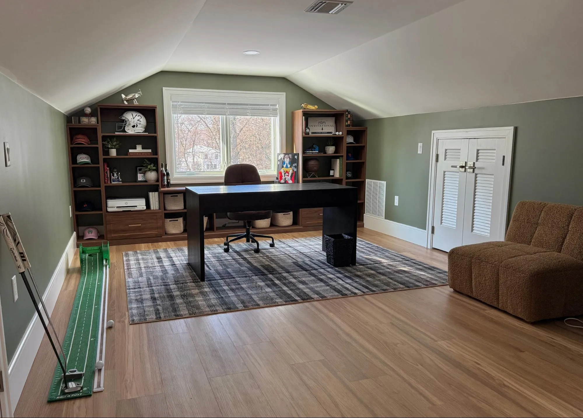 Sage green home office with desk and styled bookshelves